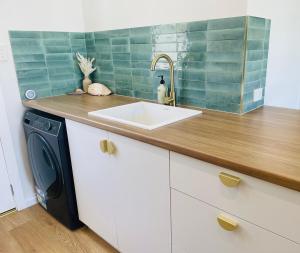 a kitchen with a sink and a washing machine at Sunrise Beach Hideaway in Exmouth +13 photos