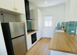 a kitchen with a refrigerator and a wooden floor at Sunrise Beach Hideaway in Exmouth