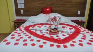 a heart made out of red hearts on a bed at Cantinho do Vale Pousada in Penedo +28 photos