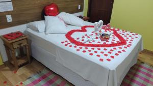 a bed with a heart shaped cake on it at Cantinho do Vale Pousada in Penedo