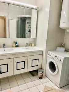 a bathroom with a washing machine and a sink at Sunshine centrum in Koksijde
