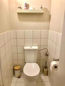 a white bathroom with a toilet and a shelf at Sunshine centrum in Koksijde