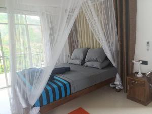 a bedroom with a canopy bed with a window at Zion Haven Villa in Tangalle