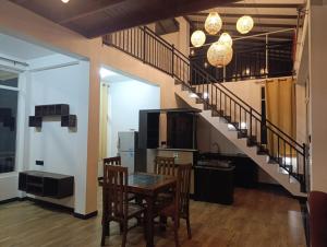 a dining room with a table and a staircase at Zion Haven Villa in Tangalle