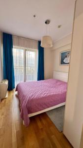 a bedroom with a purple bed and a window at Sea view apartment 2 in Boreti