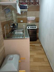 a small kitchen with a sink and a stove at Cantinho do Vale Pousada in Penedo