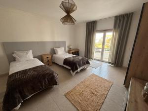 a bedroom with two beds and a window at Apartamento - The Light House in Peniche