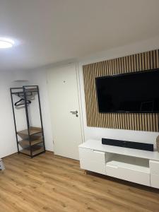 a living room with a tv and a white cabinet at Ferienwohnung Alecasa in Gailingen