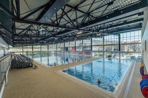 a large indoor swimming pool with people in it at Hotel ORJEN sport & pleasure in Trebinje