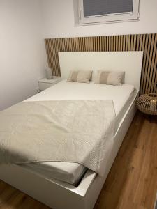 a bed with white sheets and pillows on it at Ferienwohnung Alecasa in Gailingen