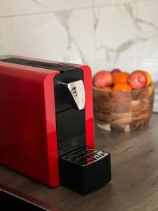 a red and black microwave sitting on a table with a basket of fruit at Ferienwohnung Alecasa in Gailingen