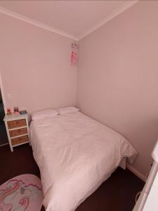 a small bedroom with a white bed and a nightstand at Chelmsford Close Pinehurst - Excellent location! in Oakdale
