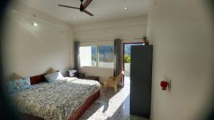 a bedroom with a bed and a window at Nileshwar Home Stay in Bāgeshwar