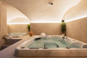 a jacuzzi tub in a room with two beds at Boutique Hotel Sablon by CW Hotel Collection in Bruges +131 photos