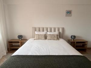 a bedroom with a large white bed with pillows at Apartamento - The Light House in Peniche +4 photos
