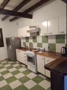 a kitchen with green and white checkered floor at Casa Fiorenza in Merlo +17 photos