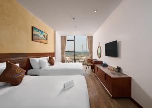 a hotel room with two beds and a television at Elegance Ninh Binh Hotel in Kỳ Vĩ