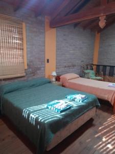 a bedroom with two beds with green sheets at Malenka in Pantanillo +19 photos
