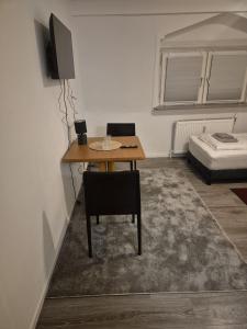 a room with a table with a television and a bed at Waterloo Sunset Hotel in Erzhausen
