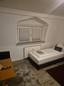 a small bedroom with a bed and a window at Waterloo Sunset Hotel in Erzhausen