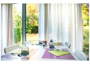 a white table with chairs and a large window at Residence Le Royal Golf & Horse in Mooslargue