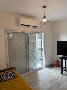 a bedroom with a sliding glass door with a balcony at Rivadavia Confort in Mariano J. Haedo