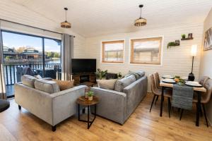 a living room with two couches and a table at Swanmere lodge, Lakeside view Pinelake Carnforth in Carnforth