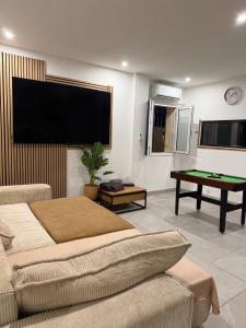 a living room with a tv and a pool table at Instant Charnel Sauna et Jacuzzi Privatif in Istres