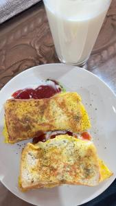 two pieces of food on a plate with a glass of milk at Mulei homestay in Wainapal