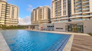 a swimming pool in front of two tall buildings at Flower Nest Apartment in Moka