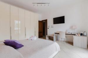 a white bedroom with a bed and a kitchen at Lamendolara B&B in Specchia