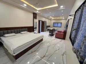 a bedroom with a bed and a living room at Hotel Keshar Palace Shani Shingnapur in Sonai
