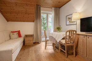 a bedroom with a bed and a table and a television at Burgunderhof in Montagna