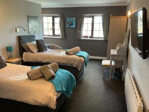 a bedroom with three beds with towels on them at Plough inn in Great Mongeham