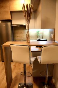 a kitchen with a counter with two chairs and a vase at Apartmán Bratislava Ružinov in Nivy