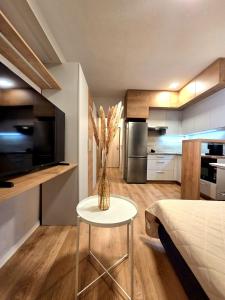 a living room with a table and a kitchen at Apartmán Bratislava Ružinov in Nivy +7 photos