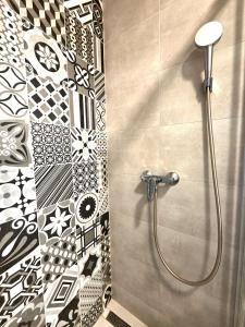 a shower in a bathroom with black and white tiles at Apartmán Bratislava Ružinov in Nivy