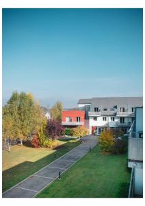 - une vue sur un bâtiment avec une pelouse et des bâtiments dans l'établissement Residence Le Royal Golf & Horse, à Mooslargue