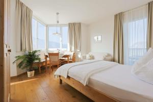 a bedroom with a bed and a table and chairs at Burgunderhof in Montagna