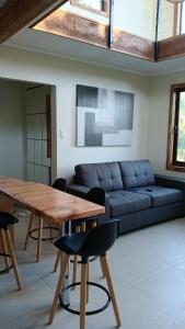 a living room with a blue couch and a wooden table at El Estuario Niebla Cabin in Niebla