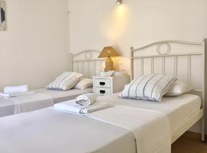 two beds sitting next to each other in a bedroom at Mykonos Dot - The Villas in Mikonos +39 photos