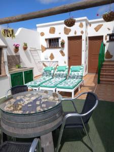 a patio with a table and chairs on a deck at Casa Tajinaste in Tinajo