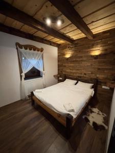 a bedroom with a bed in a room with a window at JakLak in Izvoare