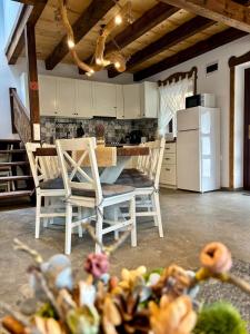 a kitchen with a table and chairs and a refrigerator at JakLak in Izvoare