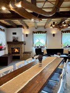 a large dining room with a wooden table and a fireplace at JakLak in Izvoare
