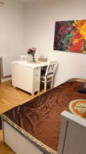 a bedroom with a desk and a painting on the wall at Villa South Beach in Karlskrona