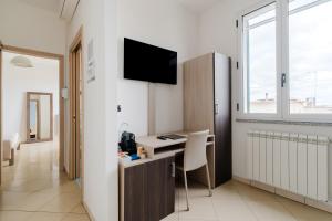 a room with a desk and a tv on a wall at Lamendolara B&B in Specchia
