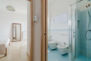 a bathroom with a toilet and a glass shower at Lamendolara B&B in Specchia +20 photos