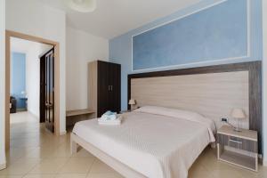 a bedroom with a large bed and a blue wall at Lamendolara B&B in Specchia