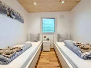 two beds in a room with white walls and a window at Chalet du calme Gersthofen in Gersthofen +25 photos